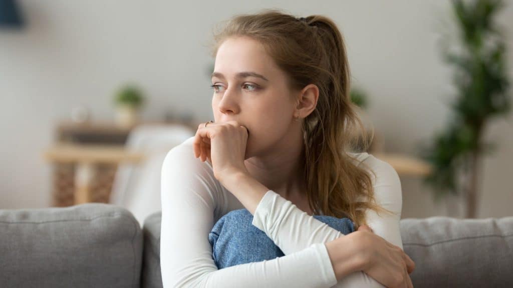 Senza di te, donna pensierosa che riflette sulla love addiction e le relazioni.