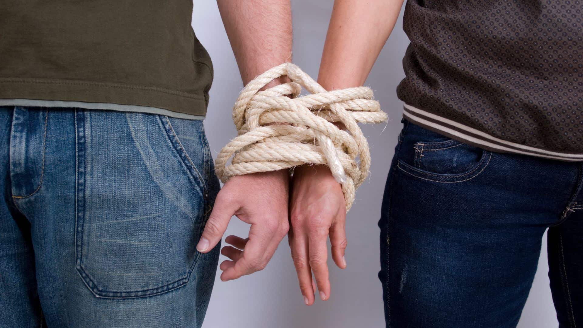 Coppia con mani legate, simbolo di dipendenza affettiva e love addiction.