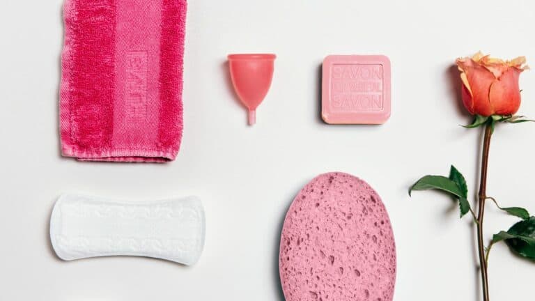 Spazzola e prodotti per l'igiene intima femminile in rosa e bianco.