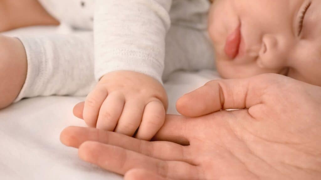 Bambino che dorme serenamente con genitore, primo anno di vita.