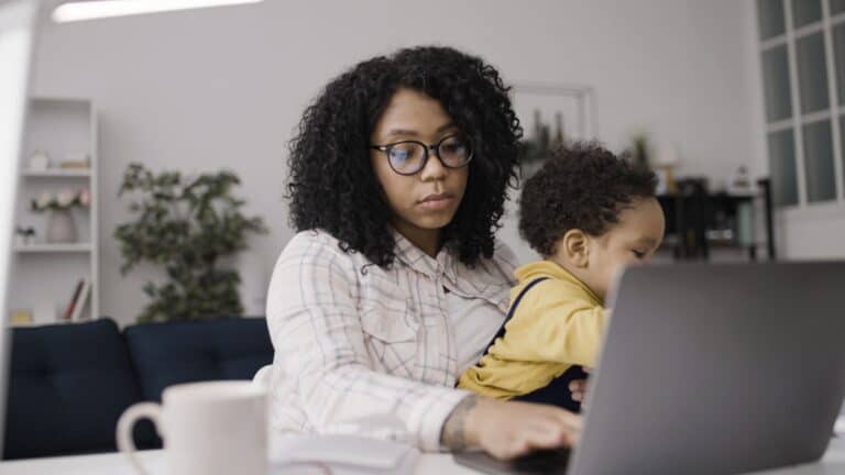 Donna con bambino che fa terapia online a casa, supporto emotivo e benessere mentale.