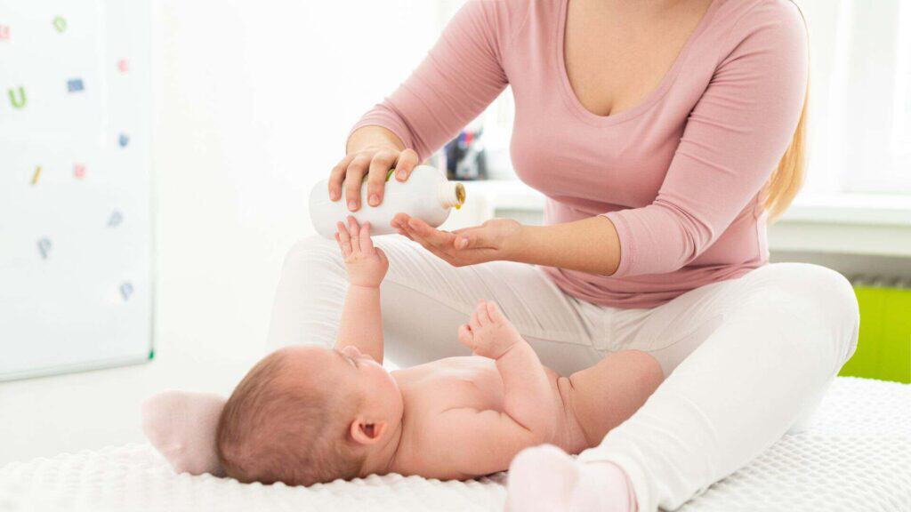 Mamma che massaggia il proprio neonato sul fasciatoio