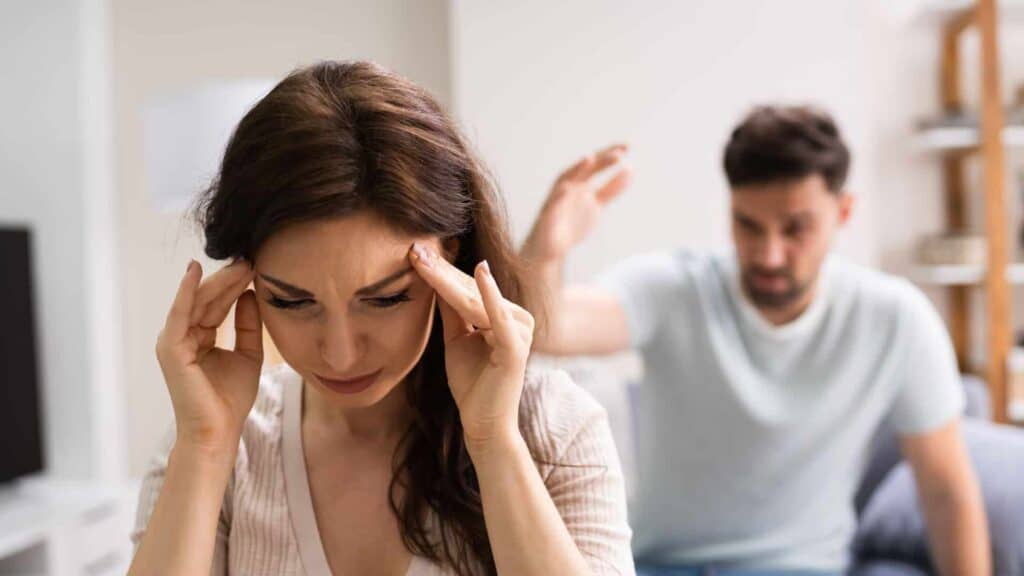 Donna preoccupata con il partner che gesticola alle sue spalle