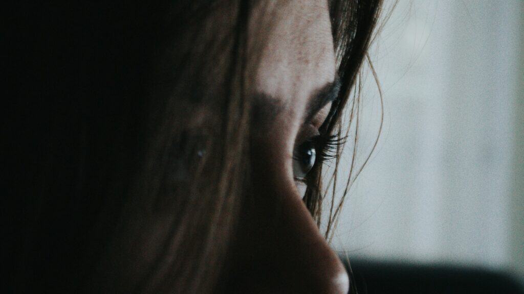 Primo piano del volto di una donna con lo sguardo rivolto altrove